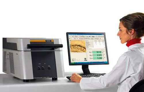 Das Röntgenfluoreszenz-Analysegerät X-RAY XAN 220 mit angeschlossenem Bildschirm, auf dem die gemessenen Anteile von Gold, Silber und Kupfer stehen