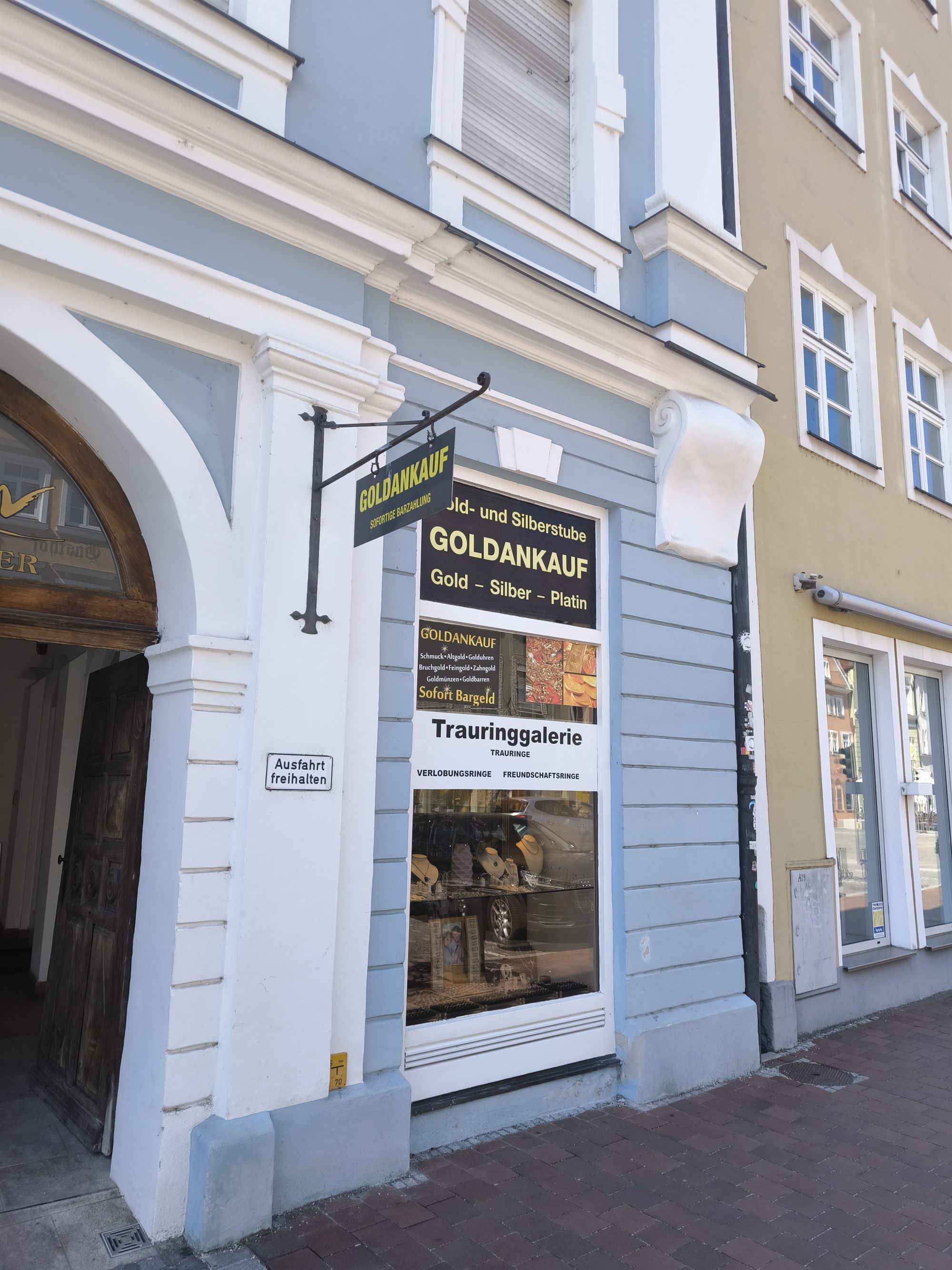 Das Geschäft in Landshut von außen, mit dem Auslegerschild „Goldankauf“ an der hellblauen Fassade